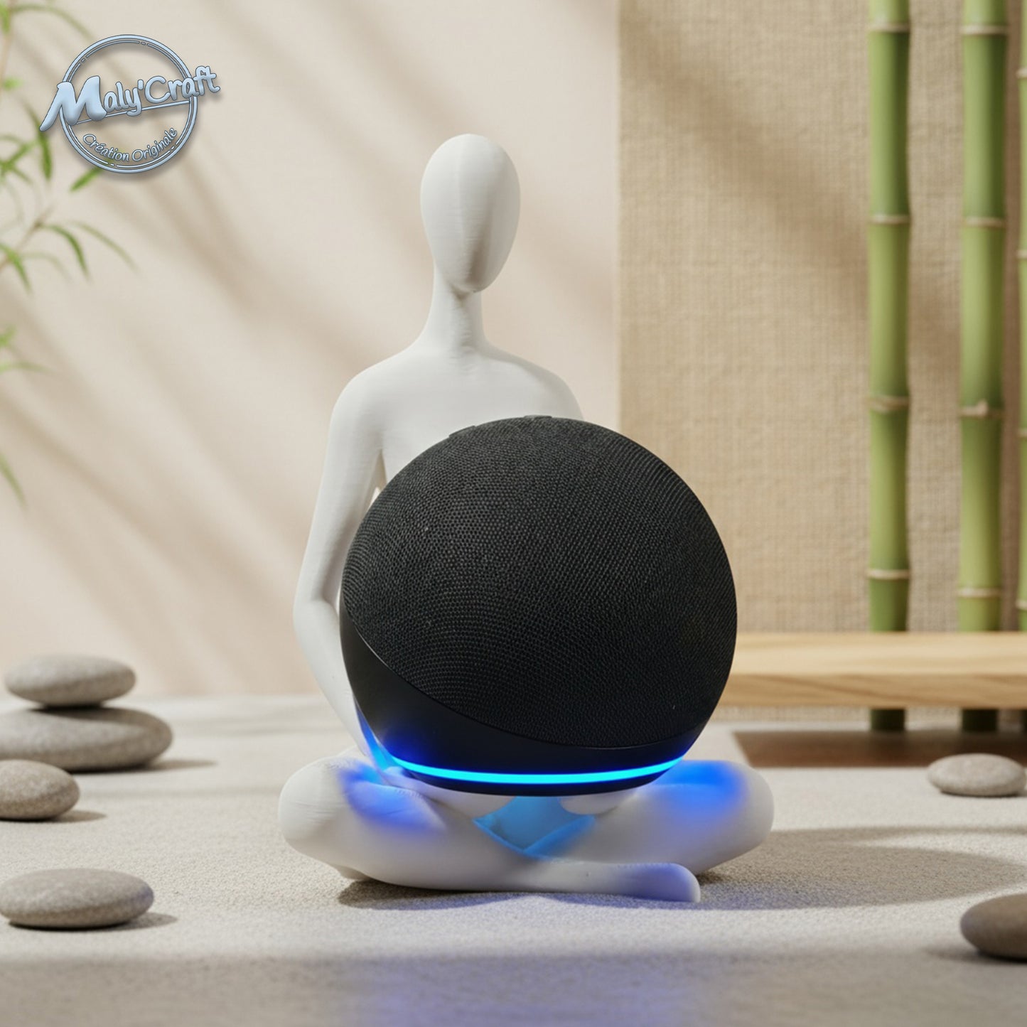 Support Maly’Craft pour enceinte Alexa Echo Dot, figurine zen en position de méditation imprimée en 3D. Design minimaliste en PLA blanc, parfait pour une déco zen et moderne. Scène apaisante avec galets et bambous en arrière-plan.