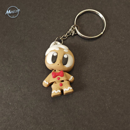 Bijou de sac articulé en forme de bonhomme de pain d'épices marron avec nœud papillon rouge, imprimé en PLA.