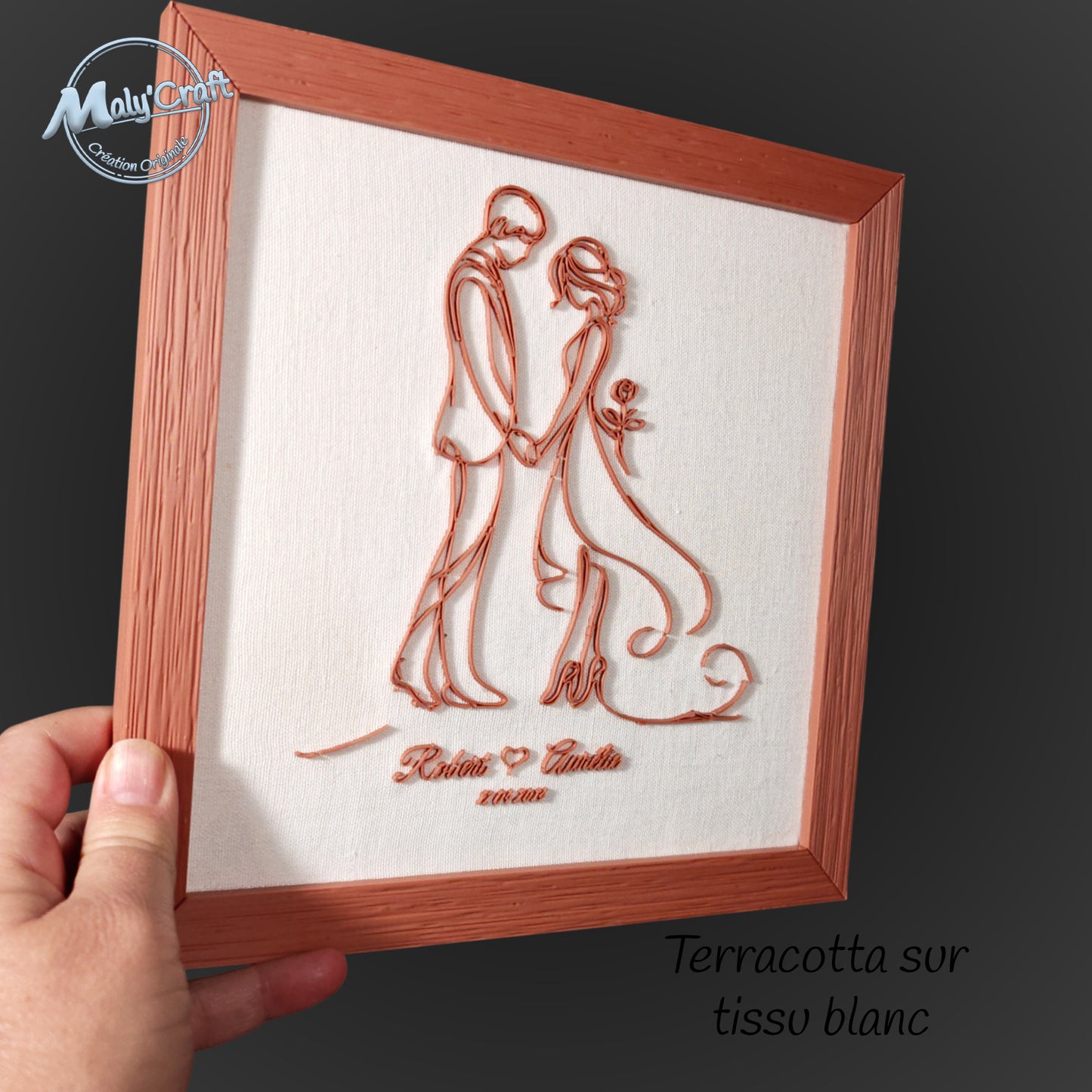 Gros plan sur le cadre mariage terracotta Maly’Craft, impression 3D fine sur tissu blanc. Détails du relief et de la texture du cadre effet bois, fabrication artisanale française.