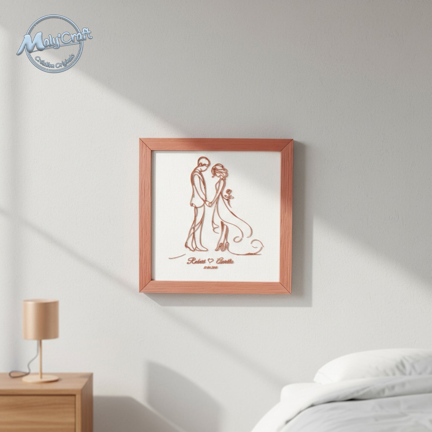 Vue rapprochée du cadre mariage Maly’Craft. Couple filaire imprimé en 3D couleur terracotta sur tissu blanc, alliance d’élégance et de douceur pour une déco artisanale.