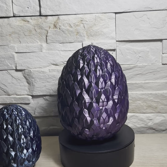 Vidéo d’un œuf de dragon violet Maly’Craft en rotation, posé sur support, avec un second œuf bleu décoratif à côté