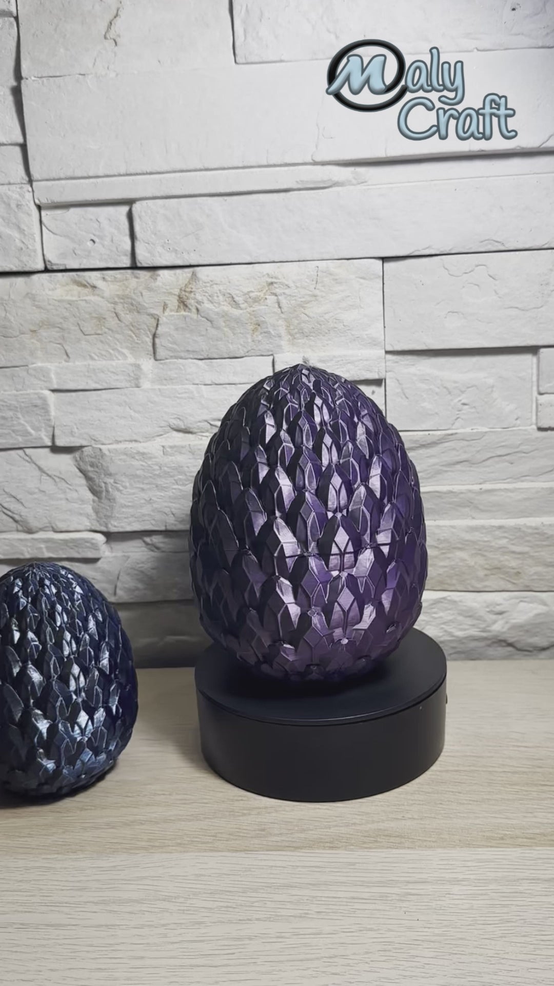 Vidéo d’un œuf de dragon violet Maly’Craft en rotation, posé sur support, avec un second œuf bleu décoratif à côté