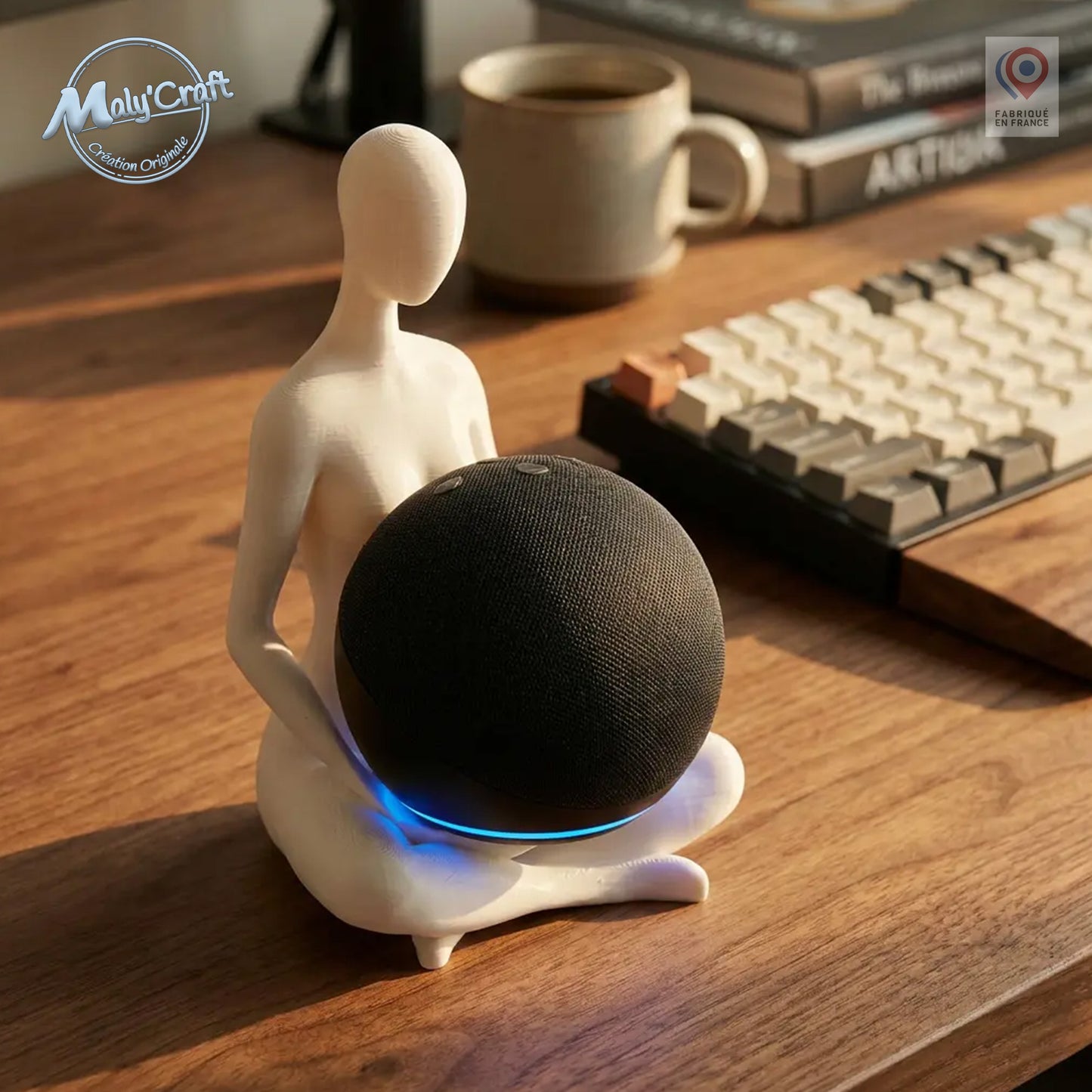Support pour enceinte connectée Echo Dot (4ème et 5ème génération) en forme de figurine humaine zen position lotus, impression 3D de précision blanche, exposé sur un bureau en bois avec éclairage chaleureux de fin de journée.